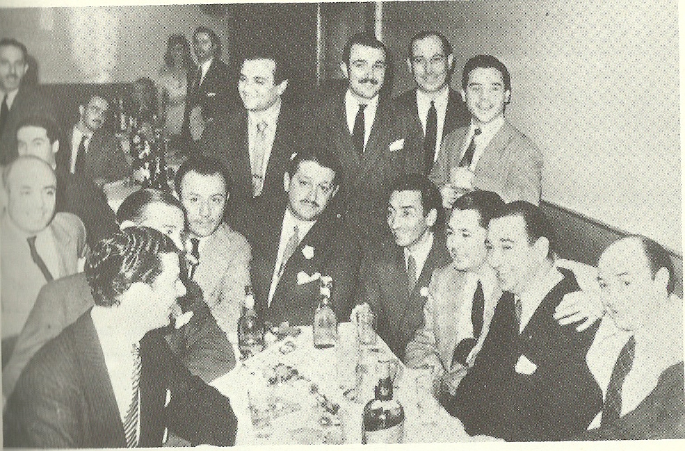 Desde la izquierda, sentados a la mesa, entre otros, Mariano Mores, Charlo (Carlos José Pérez), Enrique Santos Discépolo, Aníbal Troilo, Enrique Tanturi y Cátulo Castillo. De pie, en el centro, Alfredo Gobbi y, junto a la pared, Alberto Marino.